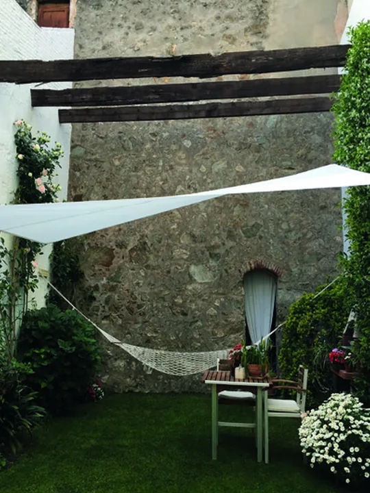 Toldo de vela blanco sobre un jardín